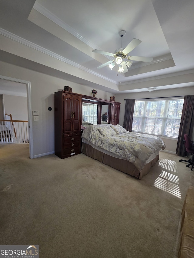 bedroom featuring multiple windows, a raised ceiling, crown molding, and light colored carpet