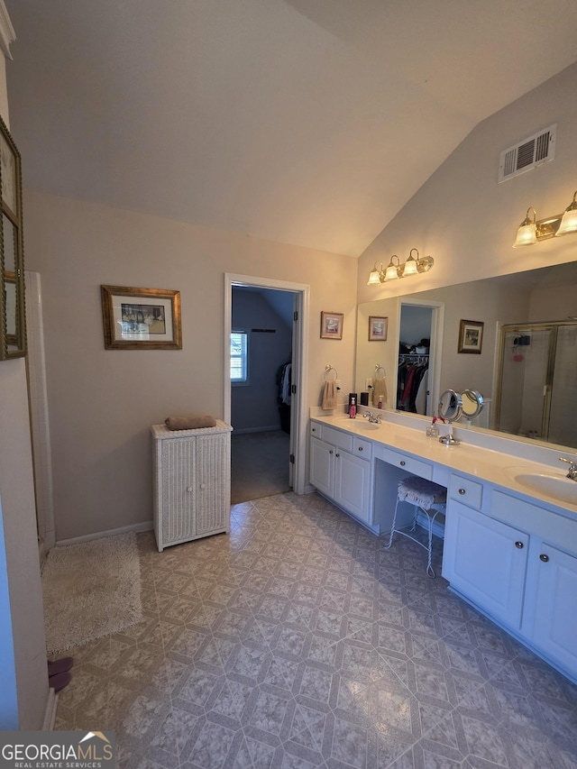 bathroom with visible vents, a spacious closet, vaulted ceiling, a shower stall, and vanity