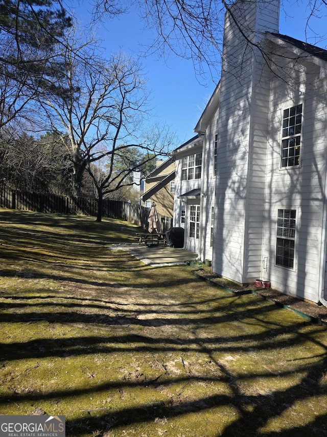 view of side of home featuring a yard and a chimney