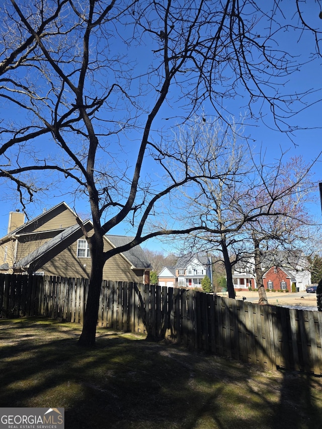 view of yard featuring fence and a residential view