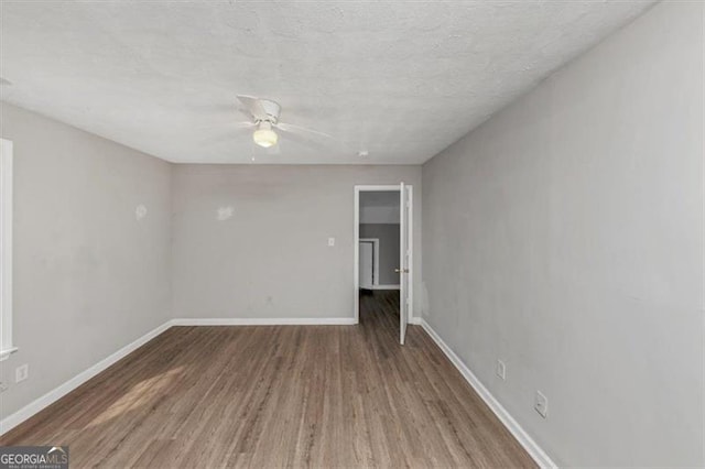 unfurnished room featuring ceiling fan, a textured ceiling, baseboards, and wood finished floors