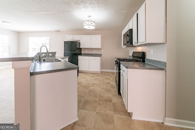 kitchen with dark countertops, white cabinets, a sink, and black appliances