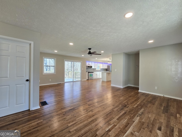 unfurnished living room featuring visible vents, dark wood-type flooring, and recessed lighting