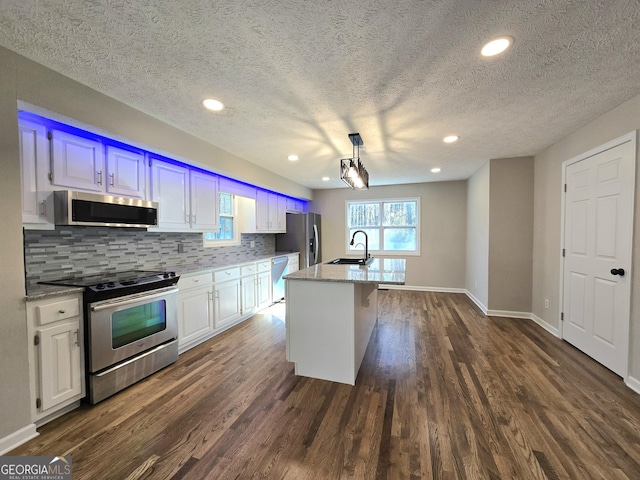 kitchen with tasteful backsplash, appliances with stainless steel finishes, dark wood finished floors, and a sink