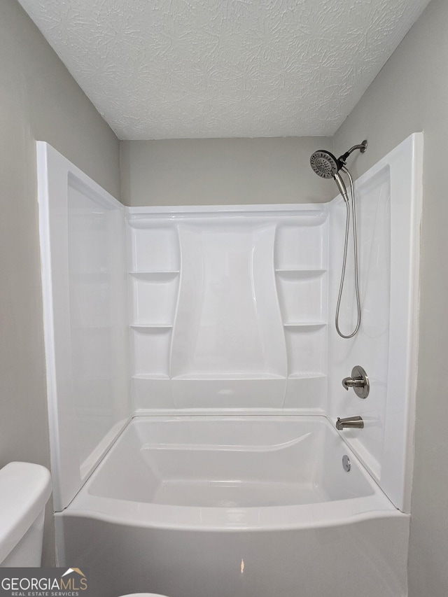 bathroom with shower / tub combination, a textured ceiling, and toilet