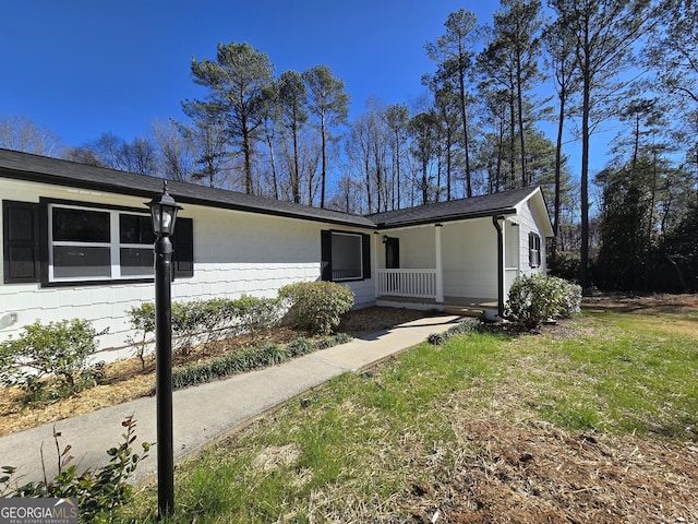 ranch-style home with covered porch and a front yard