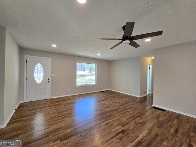 foyer entrance featuring a textured ceiling, recessed lighting, dark wood finished floors, and baseboards