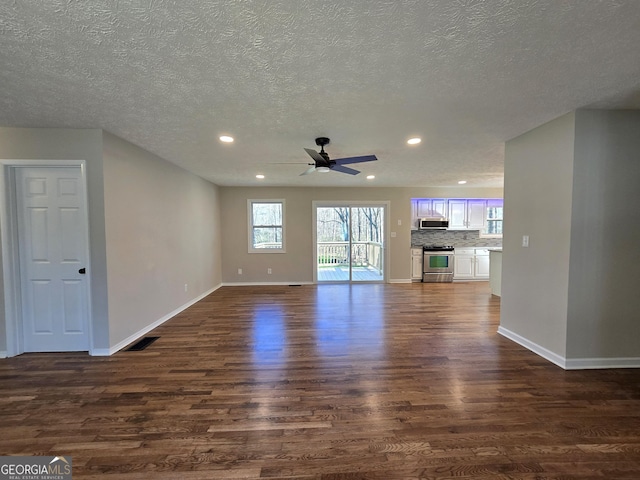 unfurnished living room with visible vents, baseboards, dark wood-type flooring, and recessed lighting