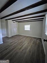 interior space featuring beamed ceiling and wood finished floors