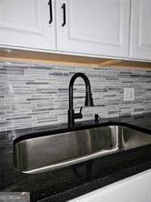 details with dark countertops, mail area, white cabinetry, and a sink