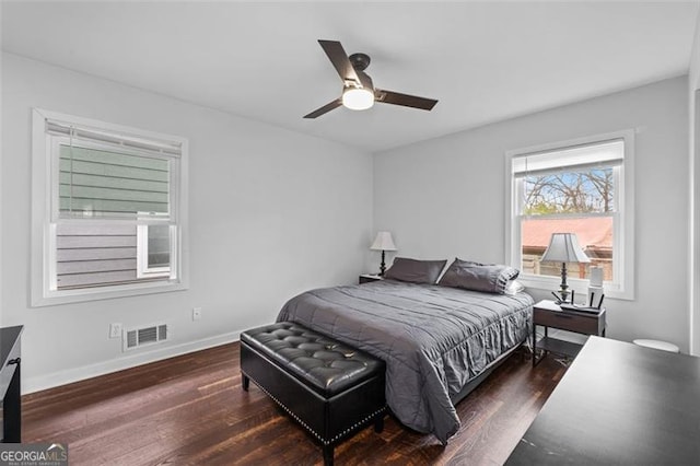 bedroom featuring visible vents, ceiling fan, baseboards, and wood finished floors