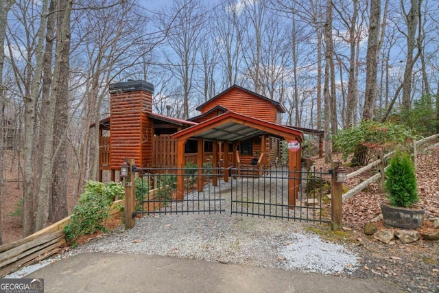 view of front of house featuring a chimney and a gate