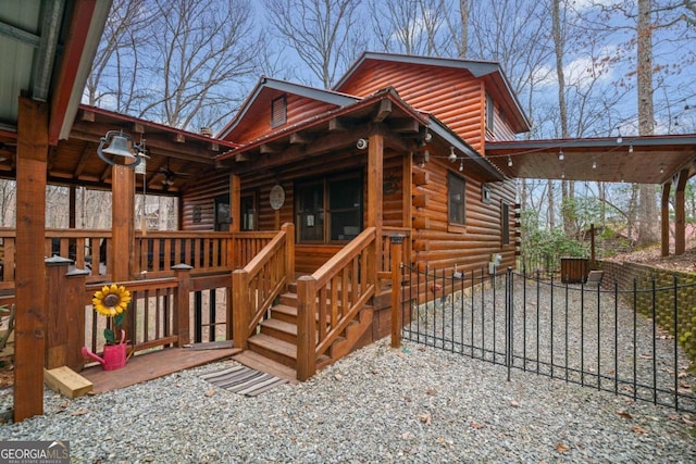 exterior space featuring ceiling fan and log siding