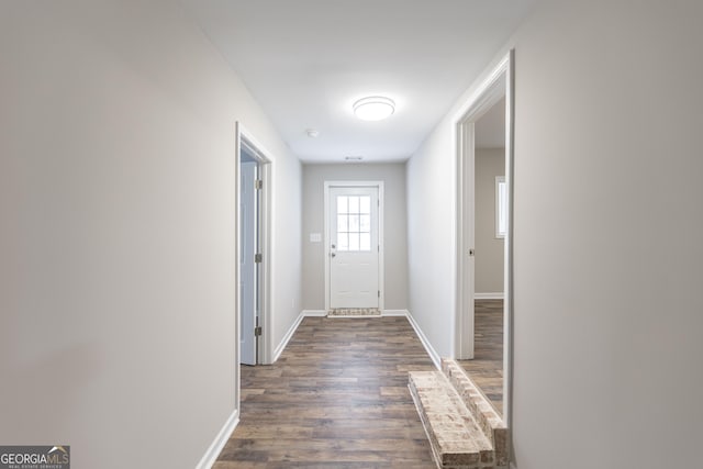 entryway featuring baseboards and dark wood-style flooring