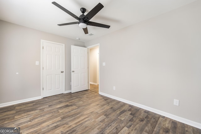 unfurnished bedroom with visible vents, wood finished floors, a ceiling fan, and baseboards