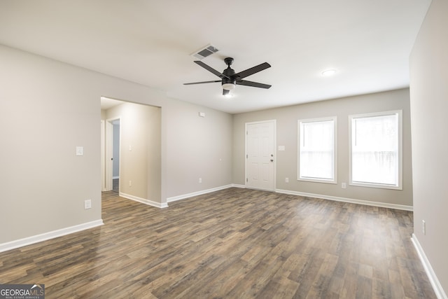 unfurnished living room featuring baseboards, visible vents, and dark wood-type flooring