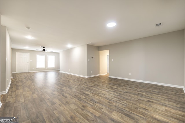 spare room featuring visible vents, dark wood finished floors, baseboards, and ceiling fan