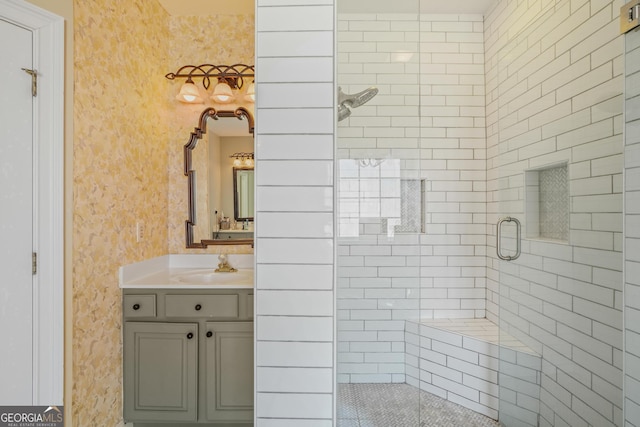 bathroom featuring a stall shower, wallpapered walls, and vanity