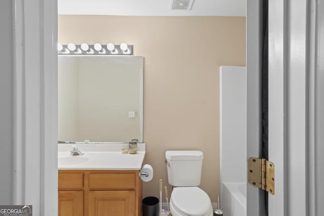 bathroom featuring visible vents, vanity, toilet, and a bath