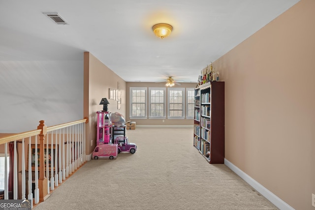 rec room with carpet floors, visible vents, ceiling fan, and baseboards