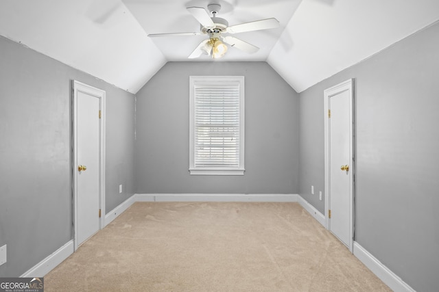 bonus room with lofted ceiling, ceiling fan, light carpet, and baseboards