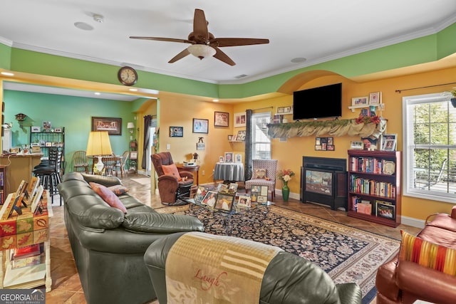 living room with baseboards, ornamental molding, a fireplace, and tile patterned floors