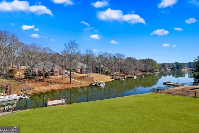 exterior space with a yard, a water view, and fence