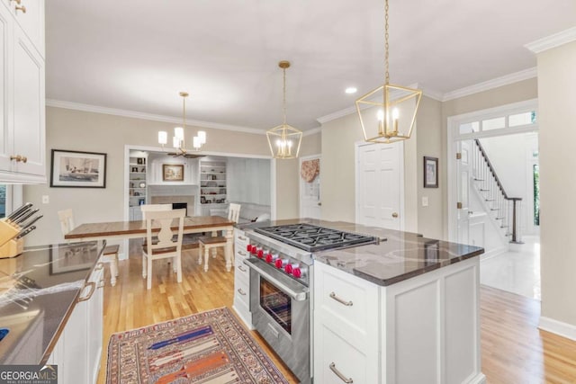 kitchen featuring white cabinets, a fireplace, stainless steel range, and light wood finished floors