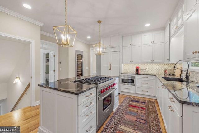 kitchen with white cabinets, stainless steel range, and a sink