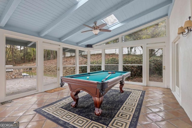 playroom with ceiling fan, lofted ceiling with skylight, plenty of natural light, and tile patterned flooring