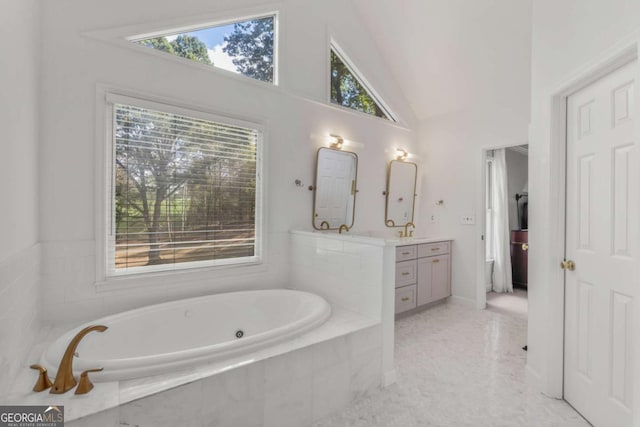 bathroom featuring a garden tub, vaulted ceiling, and vanity