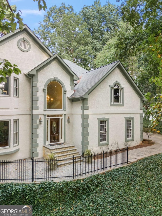 view of front facade with a fenced front yard and stucco siding