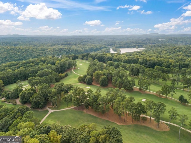 drone / aerial view with golf course view and a wooded view