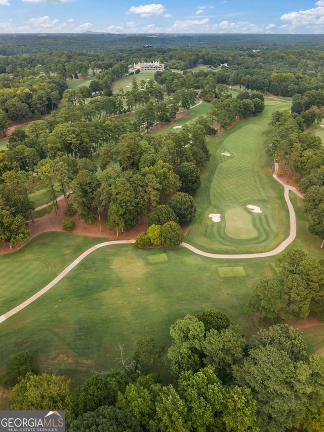 bird's eye view with golf course view and a view of trees