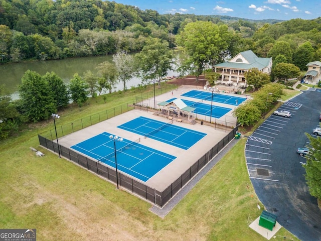 birds eye view of property featuring a water view and a wooded view