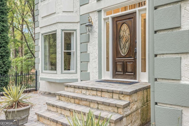 view of exterior entry with fence