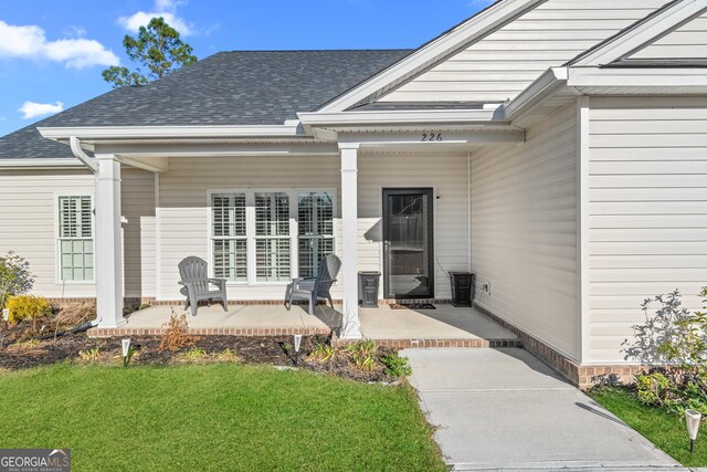 entrance to property with roof with shingles