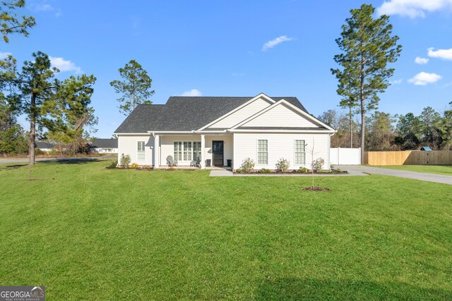 view of front of home with fence and a front lawn