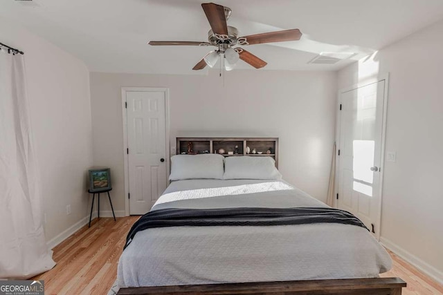 bedroom featuring ceiling fan, light wood-style flooring, and baseboards