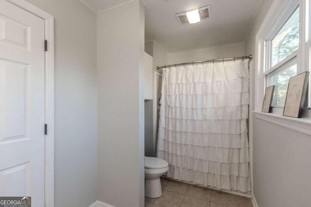 bathroom featuring a shower with shower curtain, visible vents, toilet, and tile patterned floors