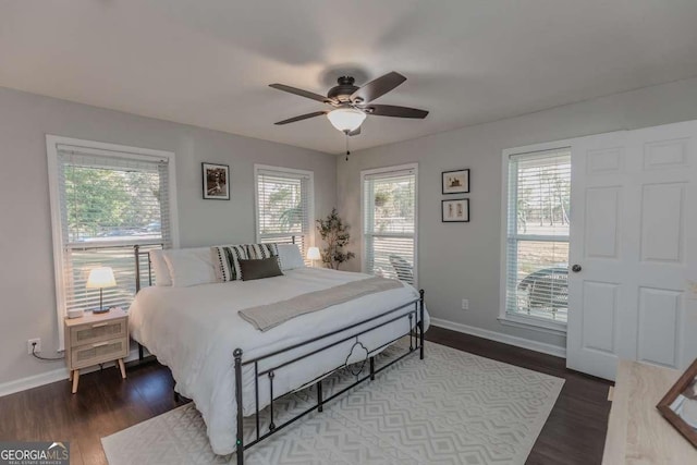 bedroom featuring dark wood finished floors, a ceiling fan, and baseboards