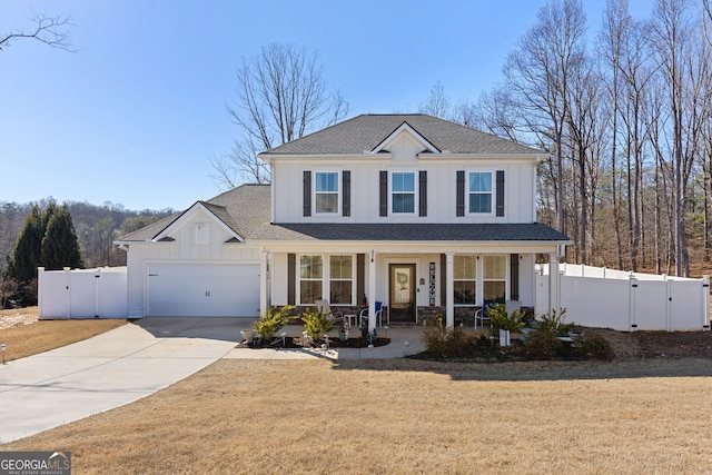 traditional-style home with a gate, fence, an attached garage, covered porch, and board and batten siding