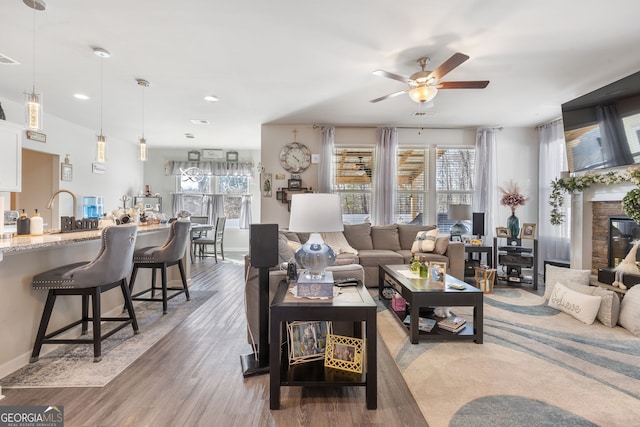 living area featuring recessed lighting, plenty of natural light, ceiling fan, and light wood finished floors