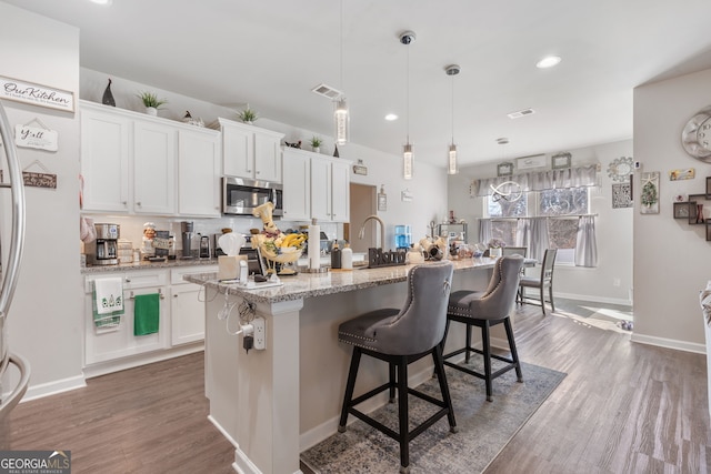 kitchen featuring stainless steel appliances, visible vents, dark wood finished floors, and white cabinets