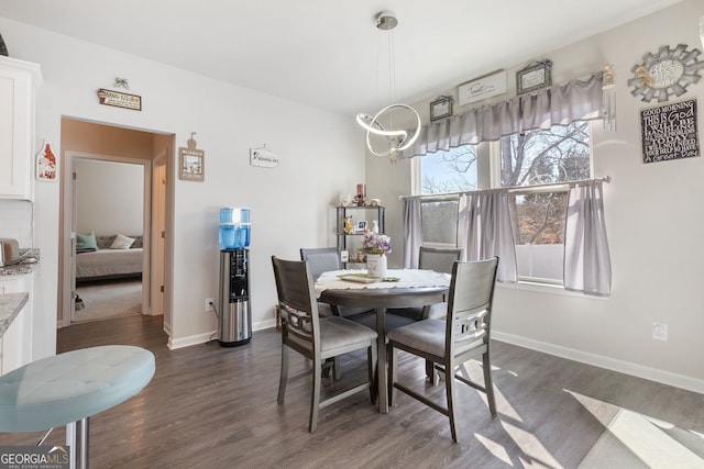 dining room featuring baseboards, dark wood-type flooring, and an inviting chandelier