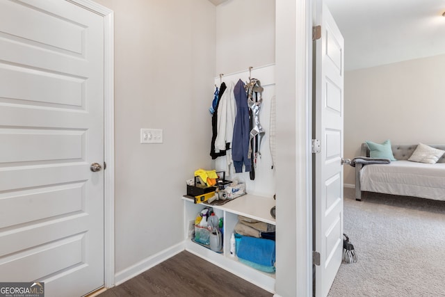 mudroom with dark wood-type flooring, baseboards, and dark colored carpet