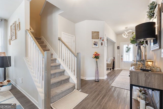 entrance foyer with stairway, wood finished floors, and baseboards