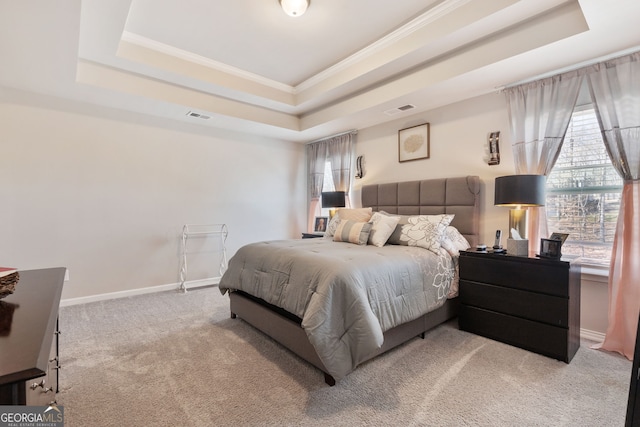 carpeted bedroom with visible vents, a raised ceiling, baseboards, and crown molding