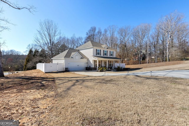 view of front of property featuring fence, a porch, concrete driveway, a front yard, and a gate