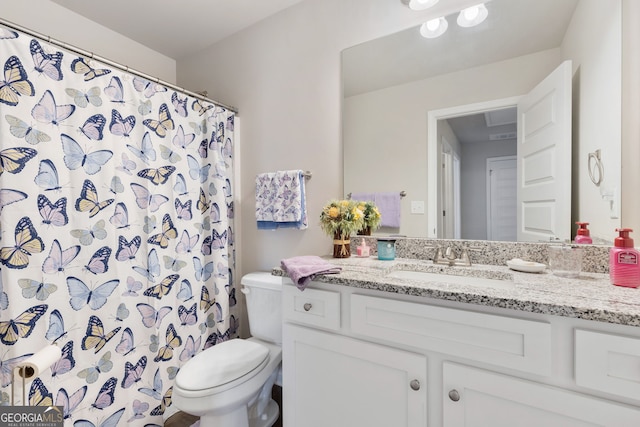 full bath featuring a shower with shower curtain, toilet, and vanity